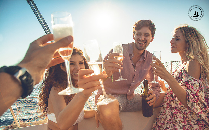 Friends celebrating a yacht birthday party with champagne and a sea breeze