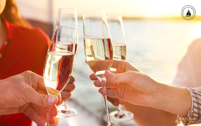 Woman holding champagne glass on a yacht sailing in the ocean